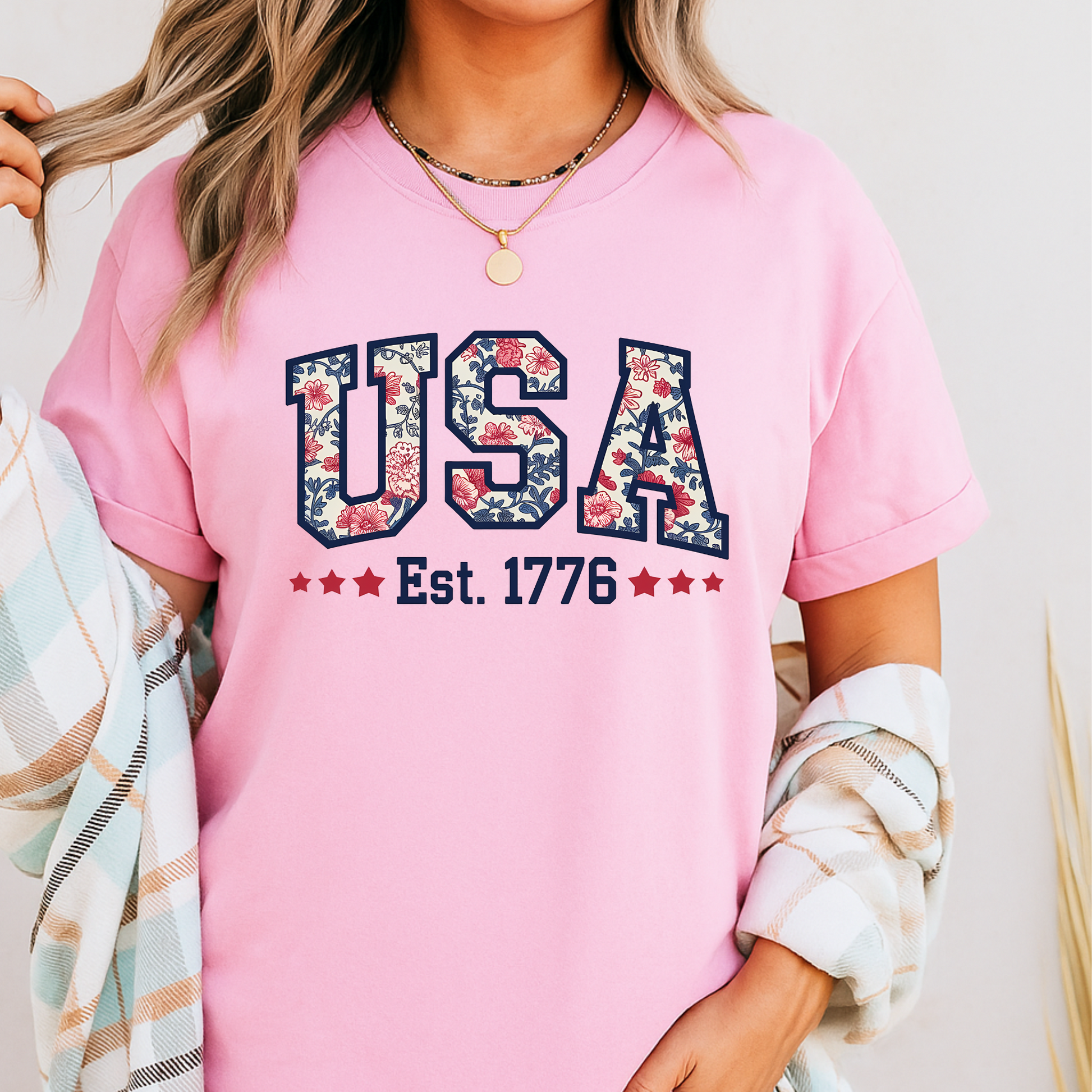  pink USA Est. 1776 shirt with floral American flag design – styled for 4th of July festivities.