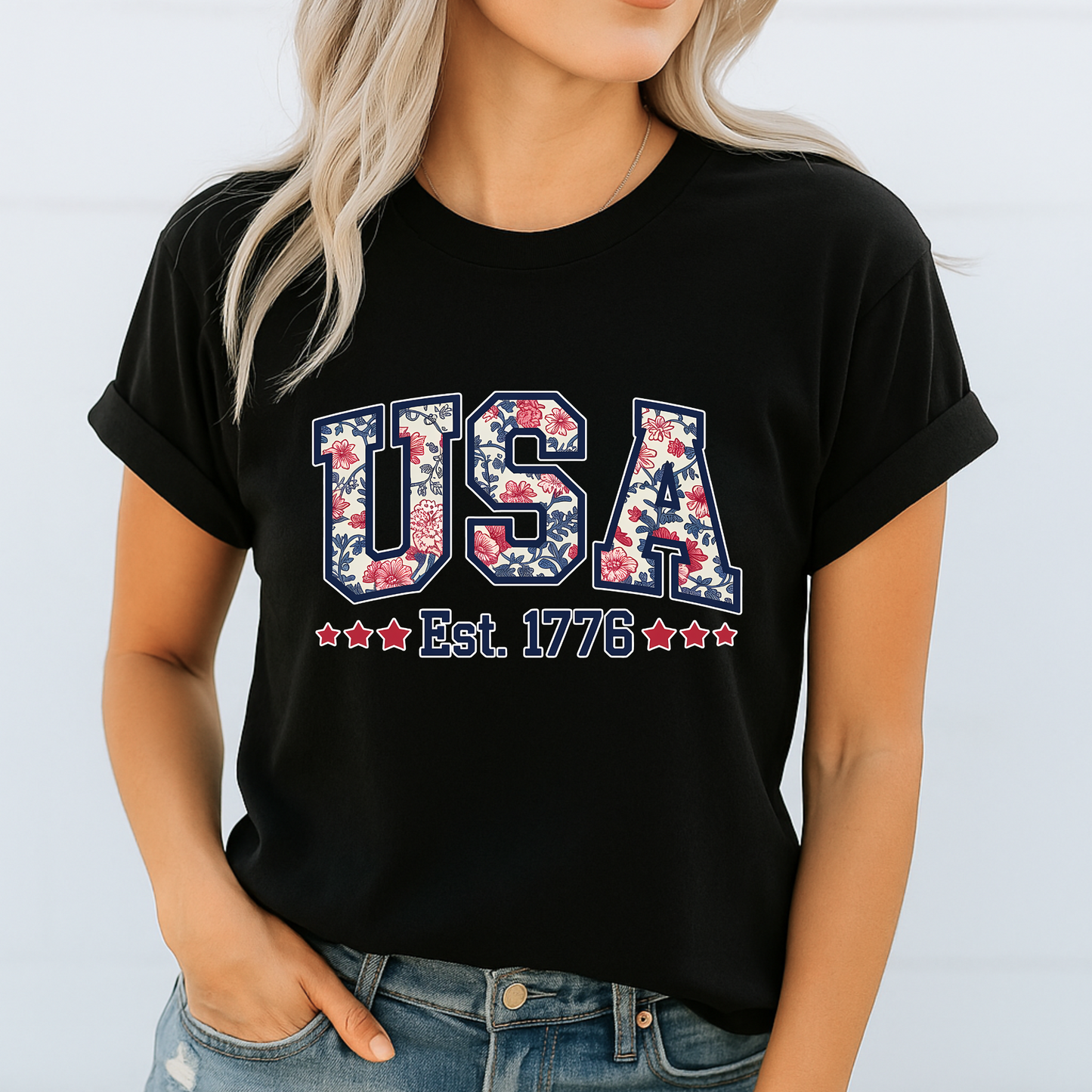 Black patriotic tee with USA Est. 1776 floral varsity print – summer-ready American pride shirt.

