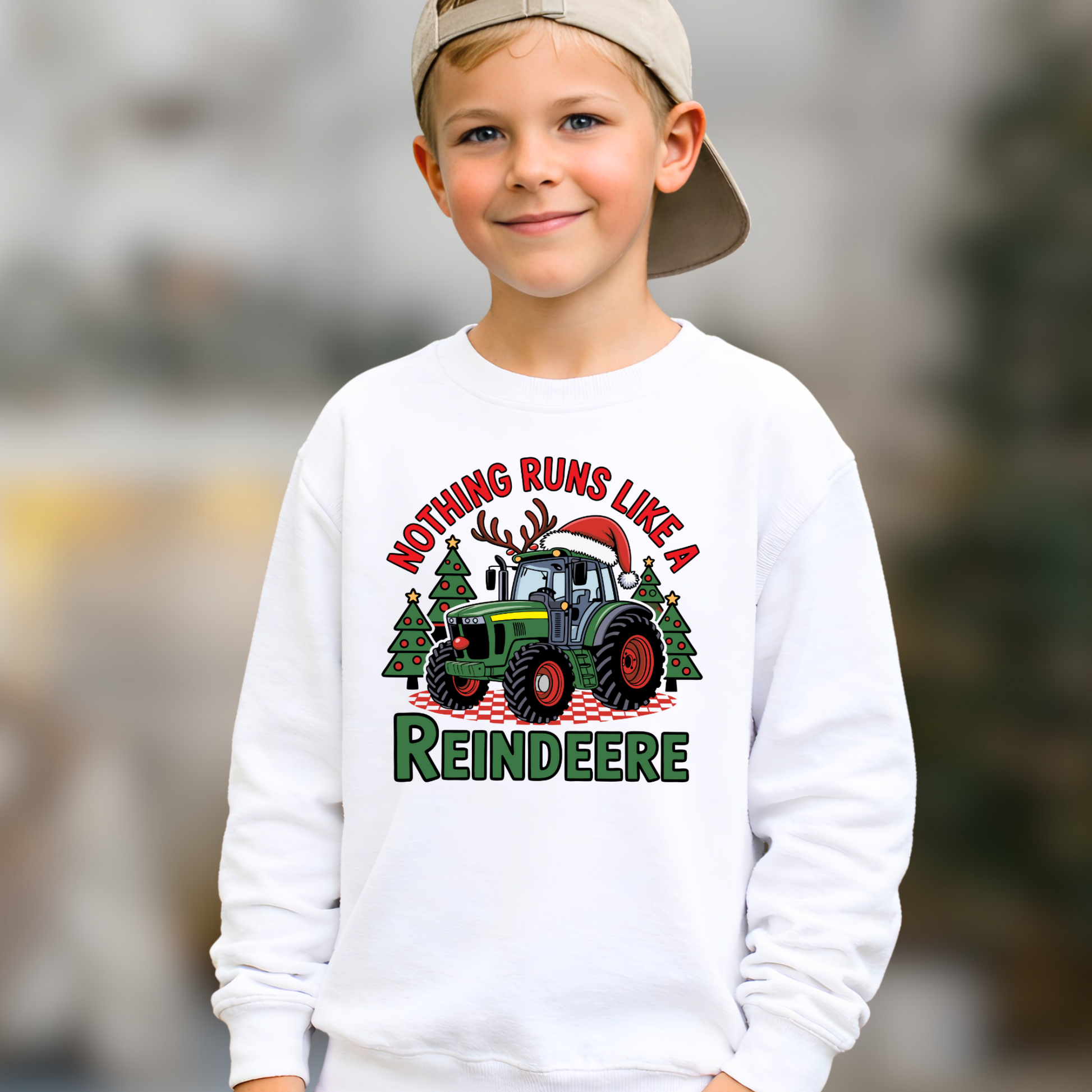 Child wearing a white sweatshirt with a Christmas-themed design featuring a tractor and reindeer.