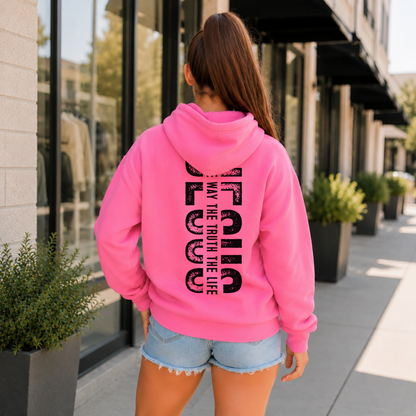 Woman shown from behind wearing a bright pink hoodie with vertical black JESUS lettering and “The Way, The Truth, The Life” text.