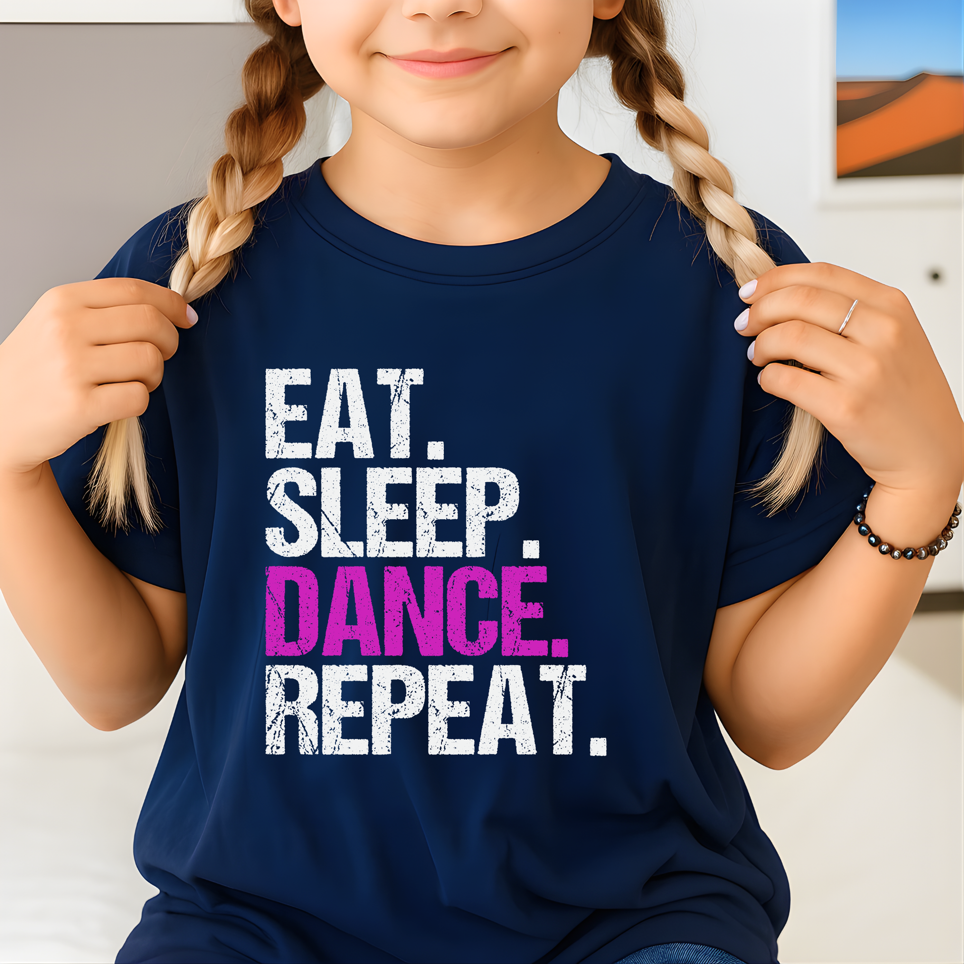 Child wearing a navy blue t-shirt with 'Eat. Sleep. Dance. Repeat.' text.