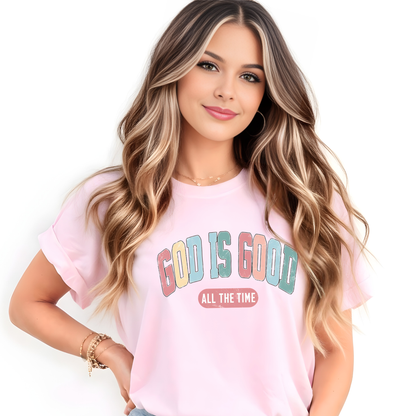 Woman wearing a pink t-shirt with 'GOD IS GOOD ALL THE TIME' text on a white background