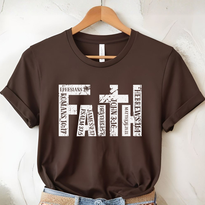Brown t-shirt with 'FAITH' design on a hanger against a white wall.