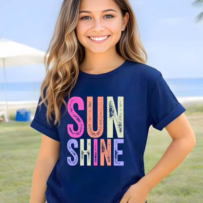 Young girl wearing a navy blue t-shirt with 'SUN SHINE' in colorful letters on a beige background