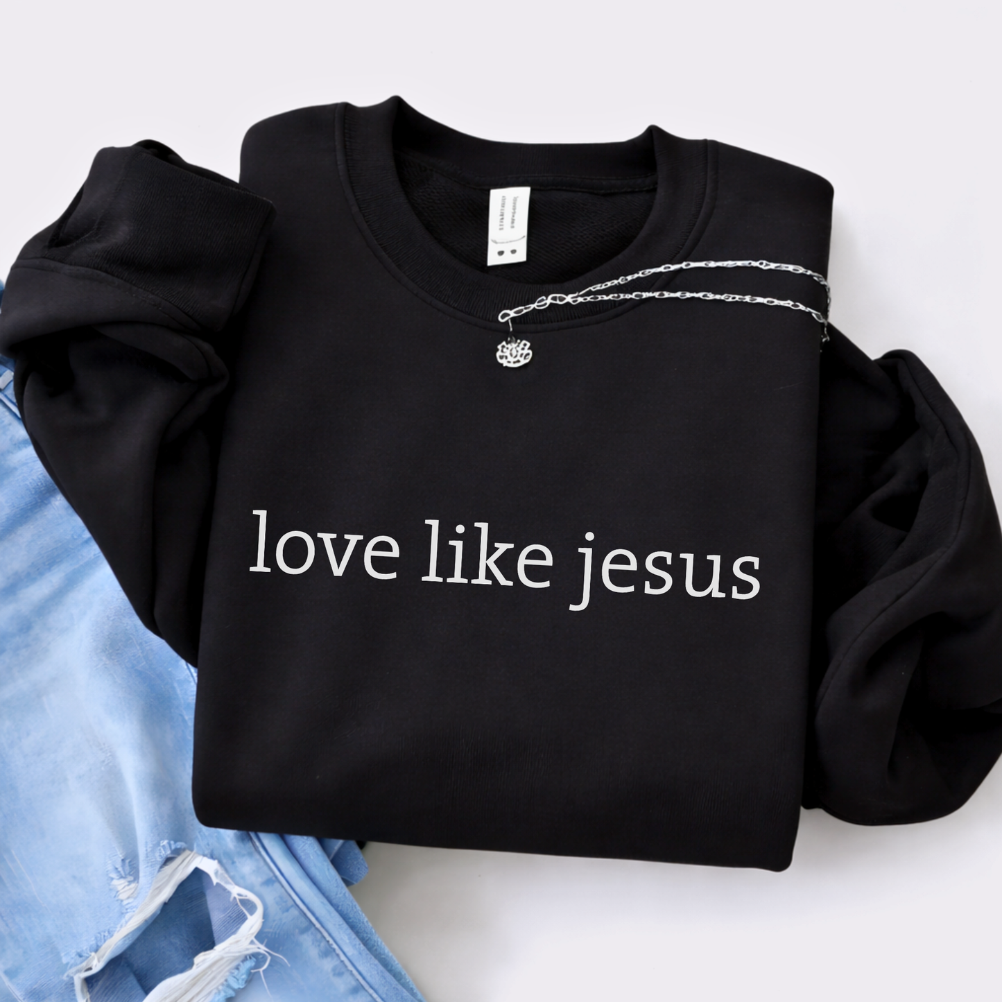Black sweatshirt with 'love like jesus' text on a white background