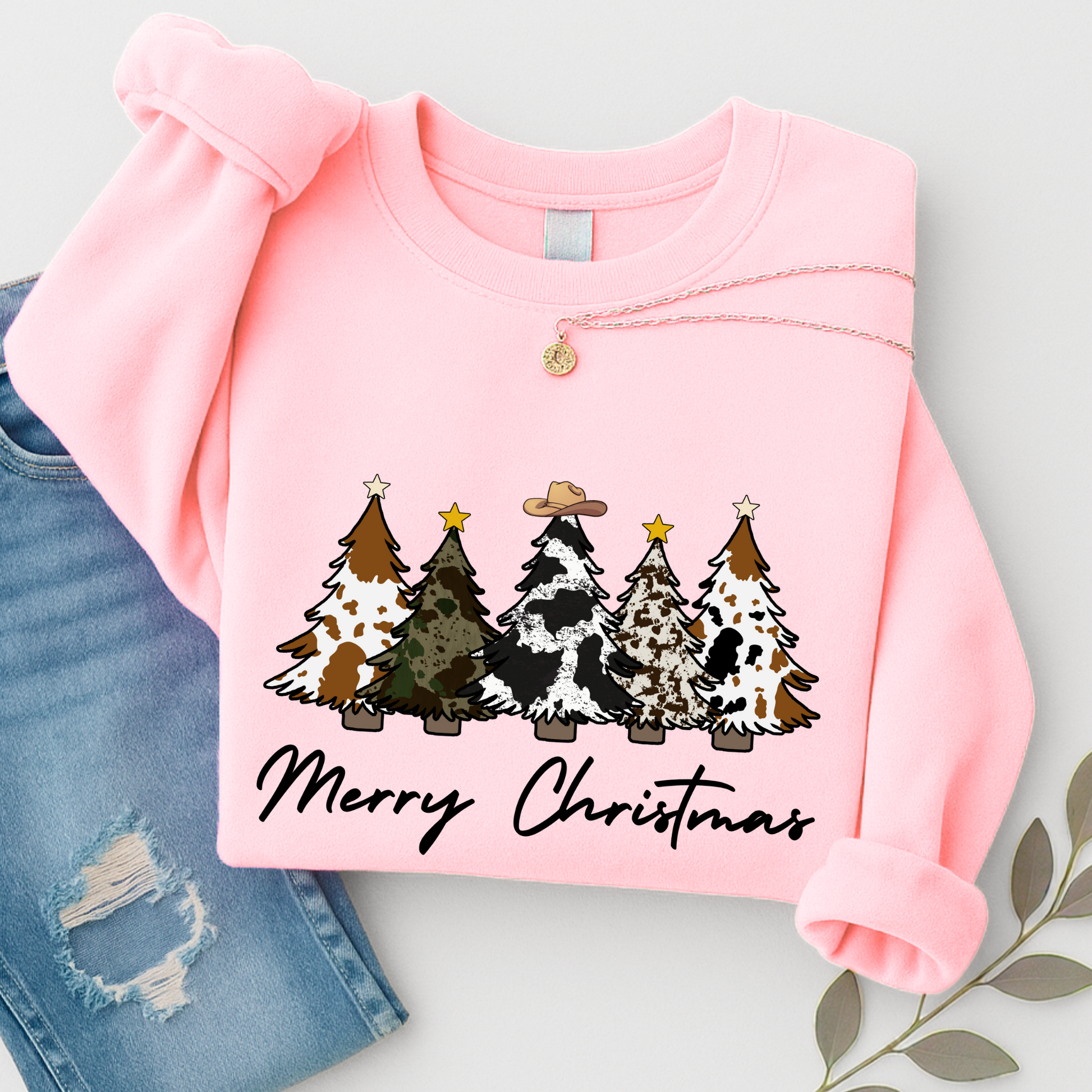 Pink sweatshirt with Christmas tree design and 'Merry Christmas' text on a light gray background.