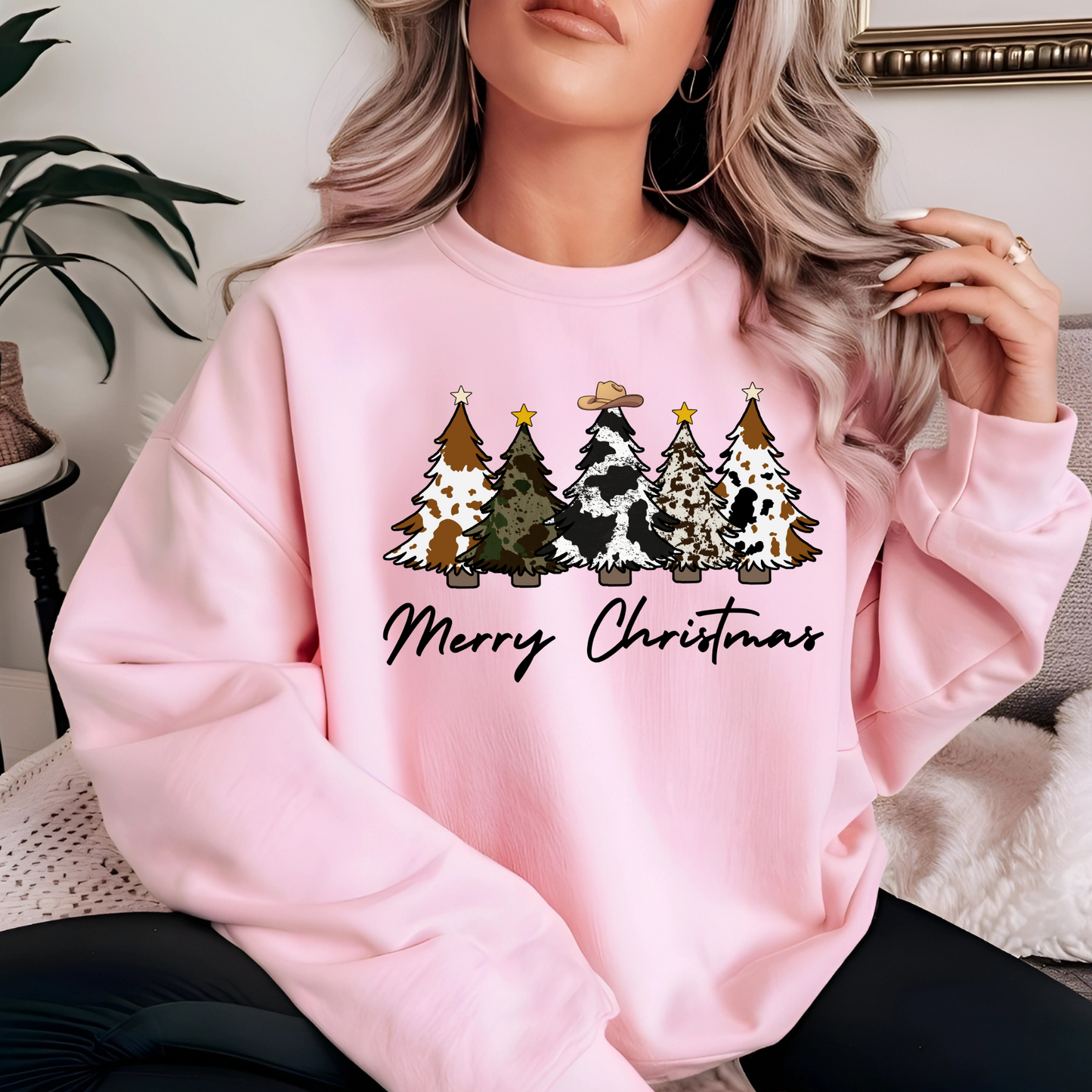 Girl wearing a pink sweatshirt with Christmas tree design and 'Merry Christmas' text.