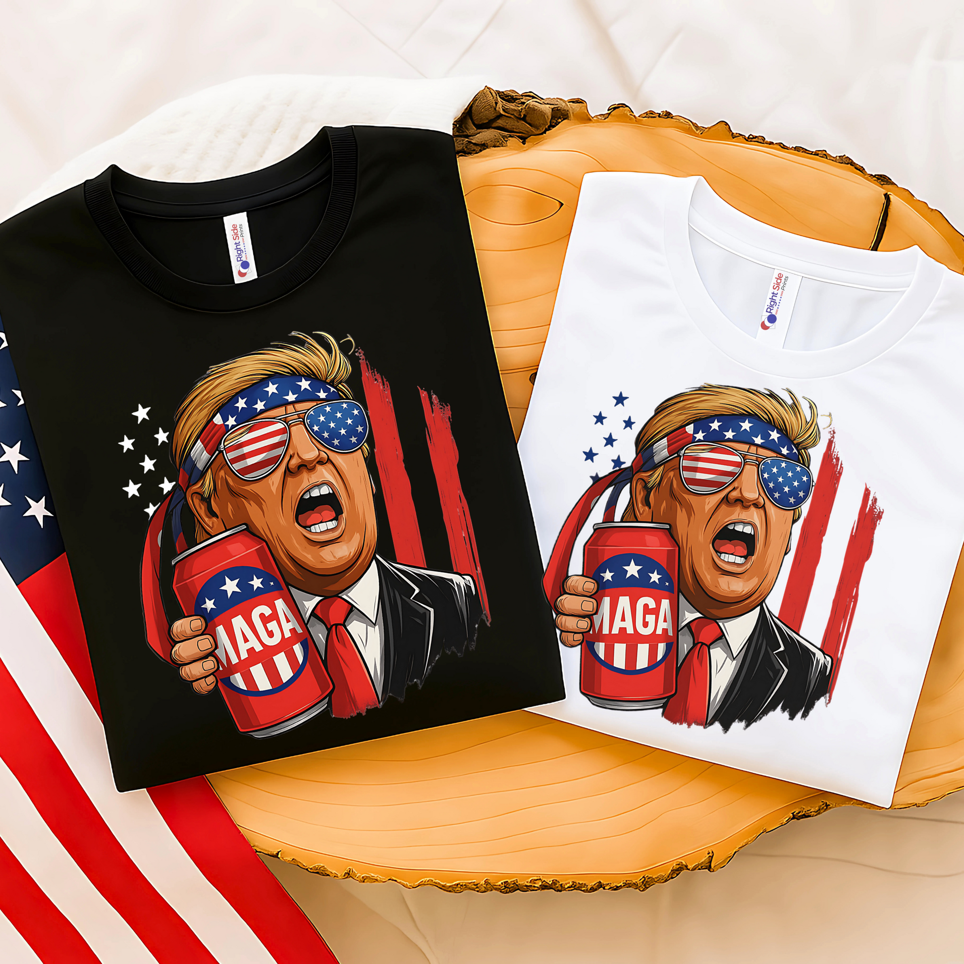 Folded black and white tees with Trump MAGA beer print, USA flag in background, perfect for patriotic gift ideas.