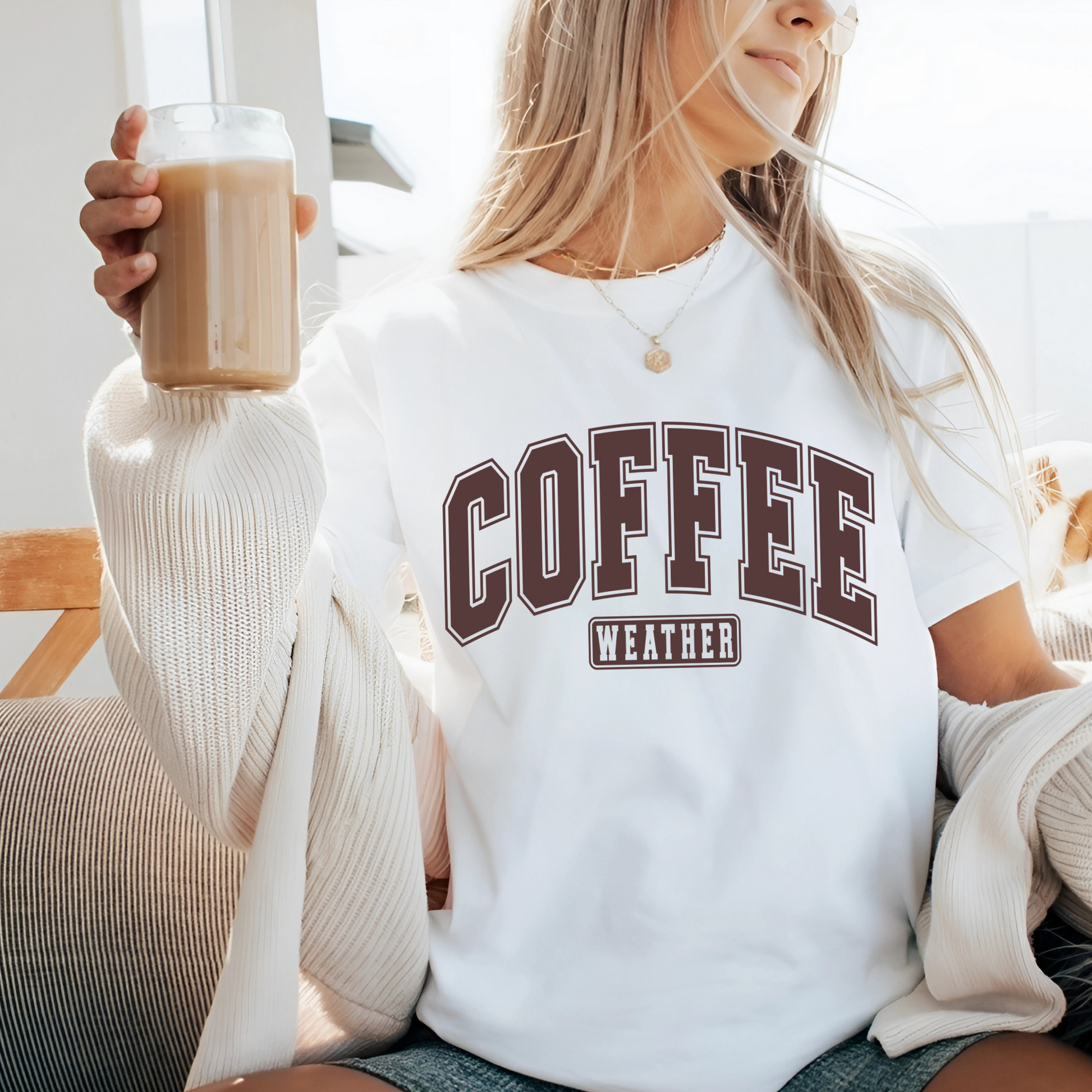 White coffee tee worn on patio with coffee glass, cozy sweater style
