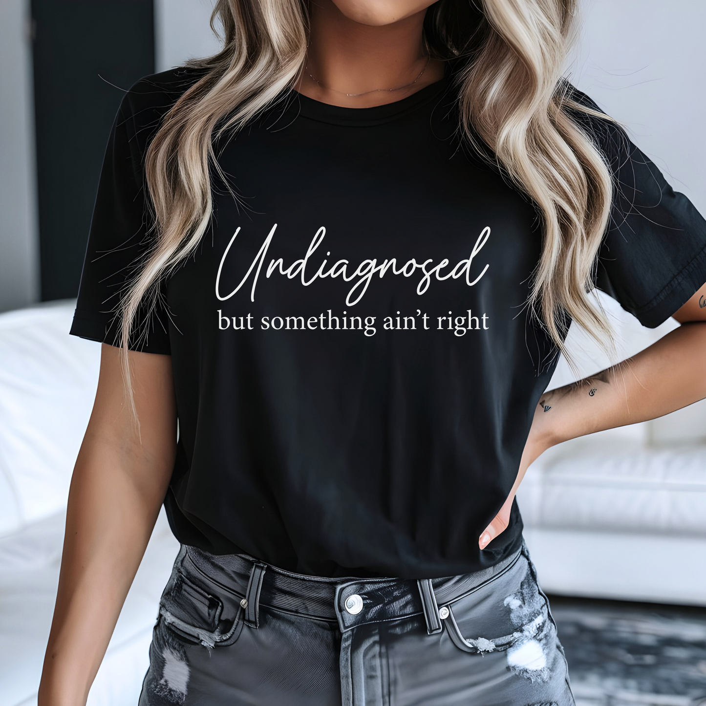 Woman in black tee with white design and distressed jeans