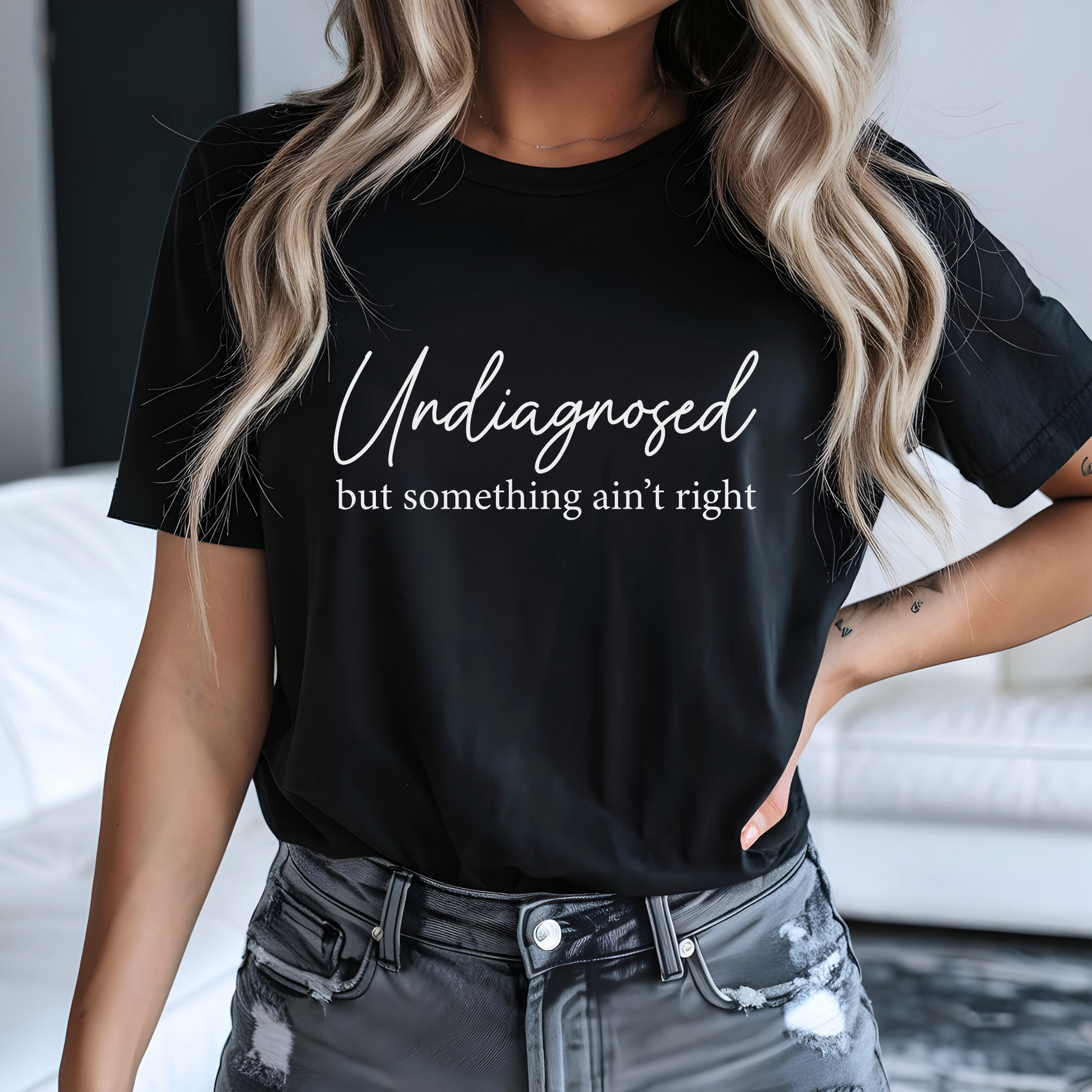 Woman in black tee with white design and distressed jeans