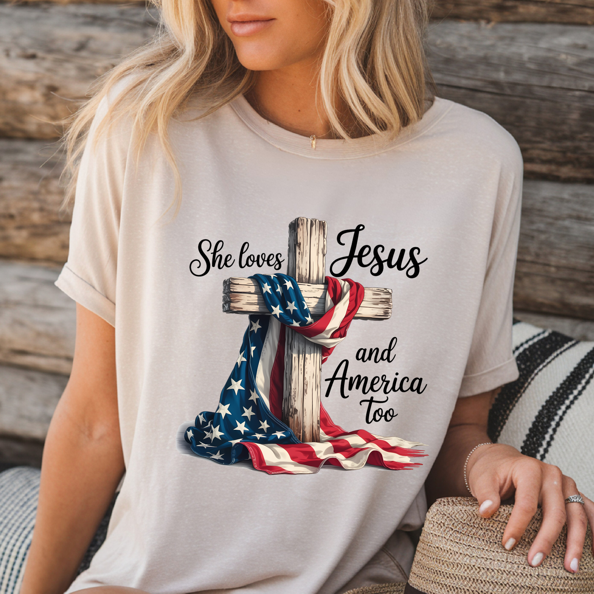 Woman in sand color “Jesus and America” shirt sitting outdoors
