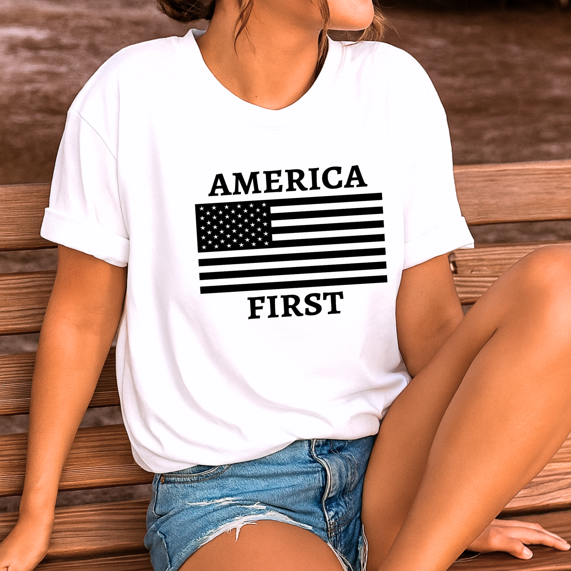 Woman sitting in a white tee with “America First” graphic, casual outdoors