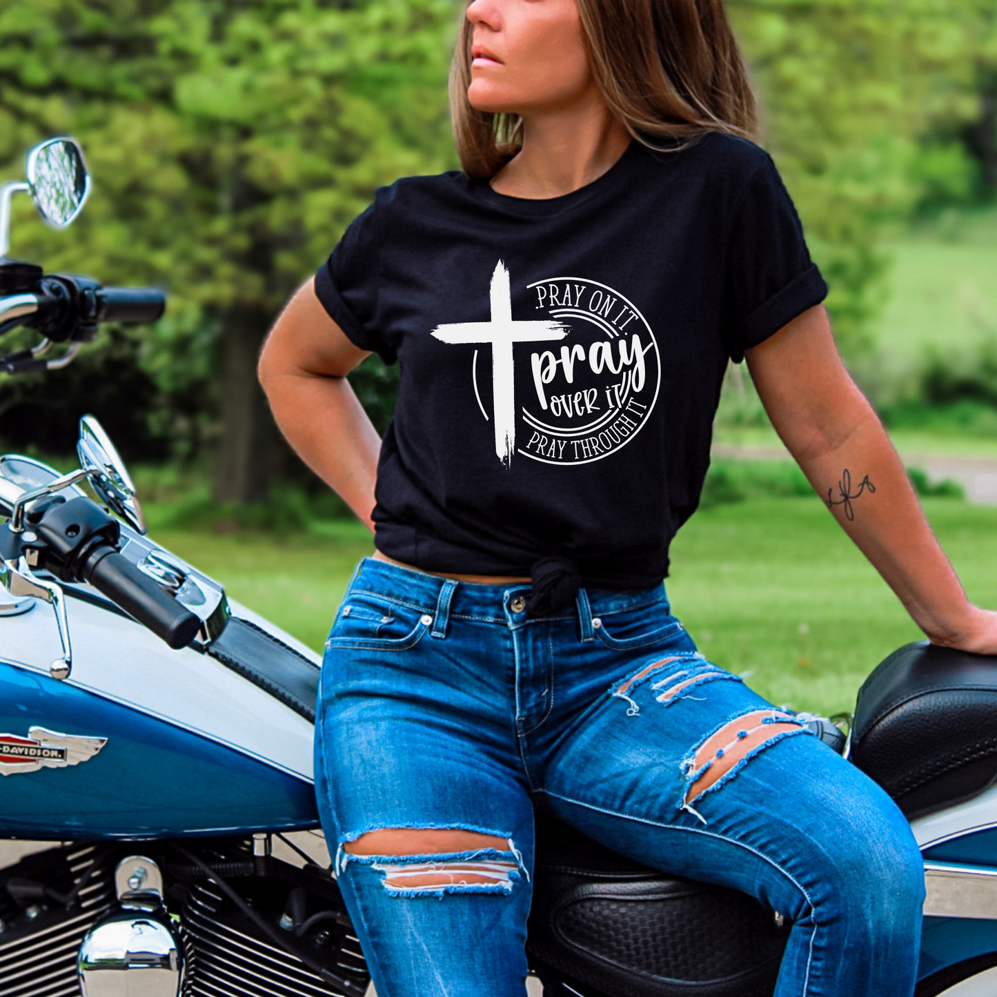 Woman wearing Black T-shirt with black cross graphic and inspirational pray wording.