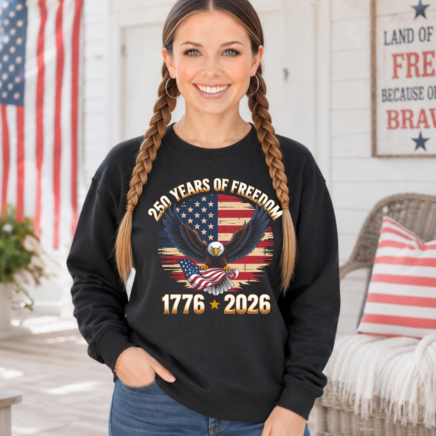Woman wearing a black sweatshirt with an eagle and American flag design, standing in front of an American flag.