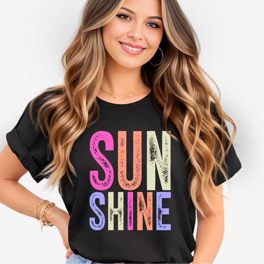 Woman wearing a black t-shirt with 'SUN SHINE' in colorful letters on a white background