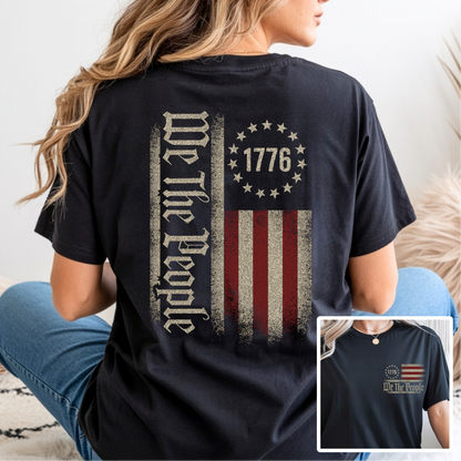 Person wearing a black t-shirt with 'We The People' and American flag design.