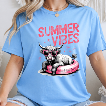 Woman  wearing a blue t-shirt with a highland cow graphic and 'Summer Vibes' text.