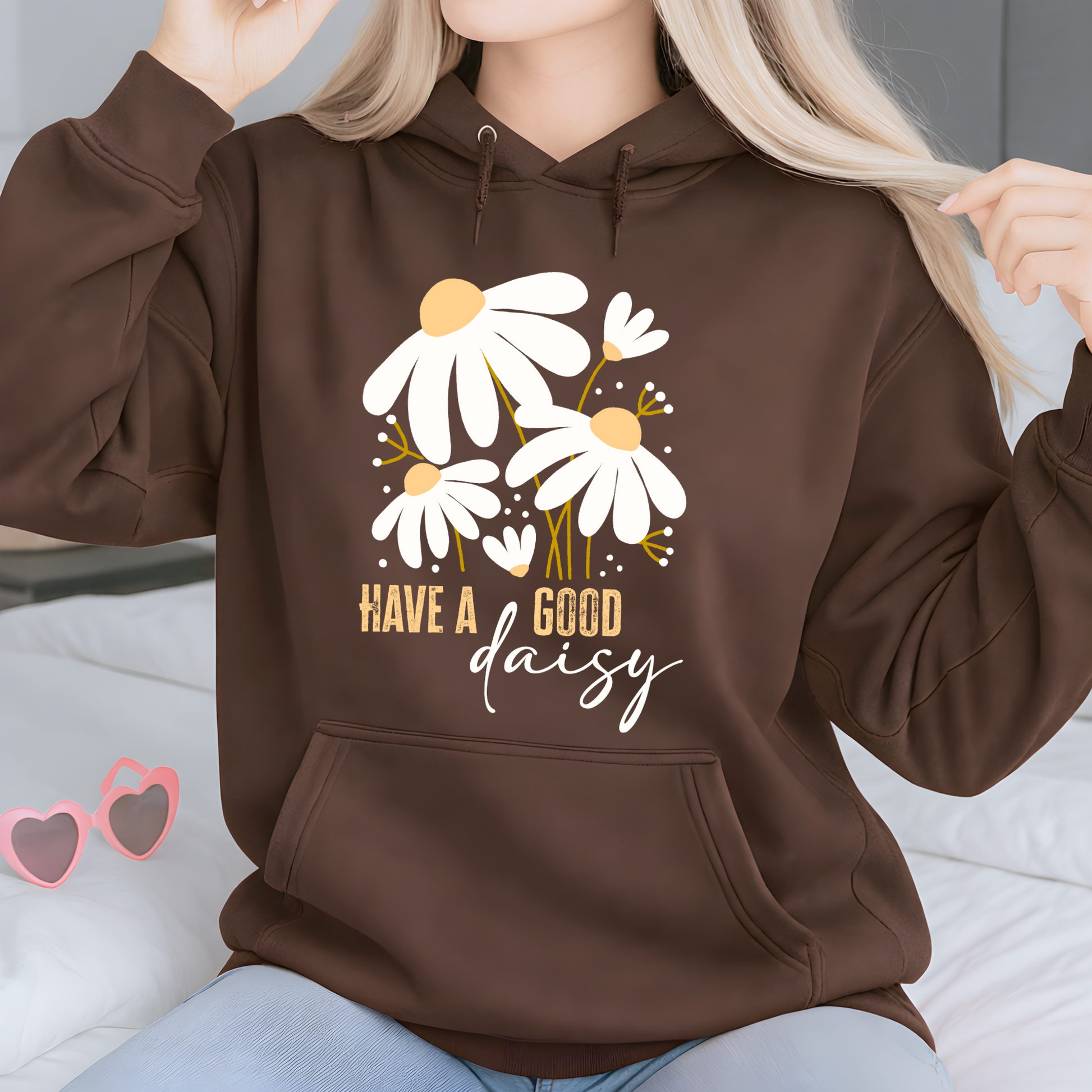 Woman wearing a brown "Have a good daisy" hoodie