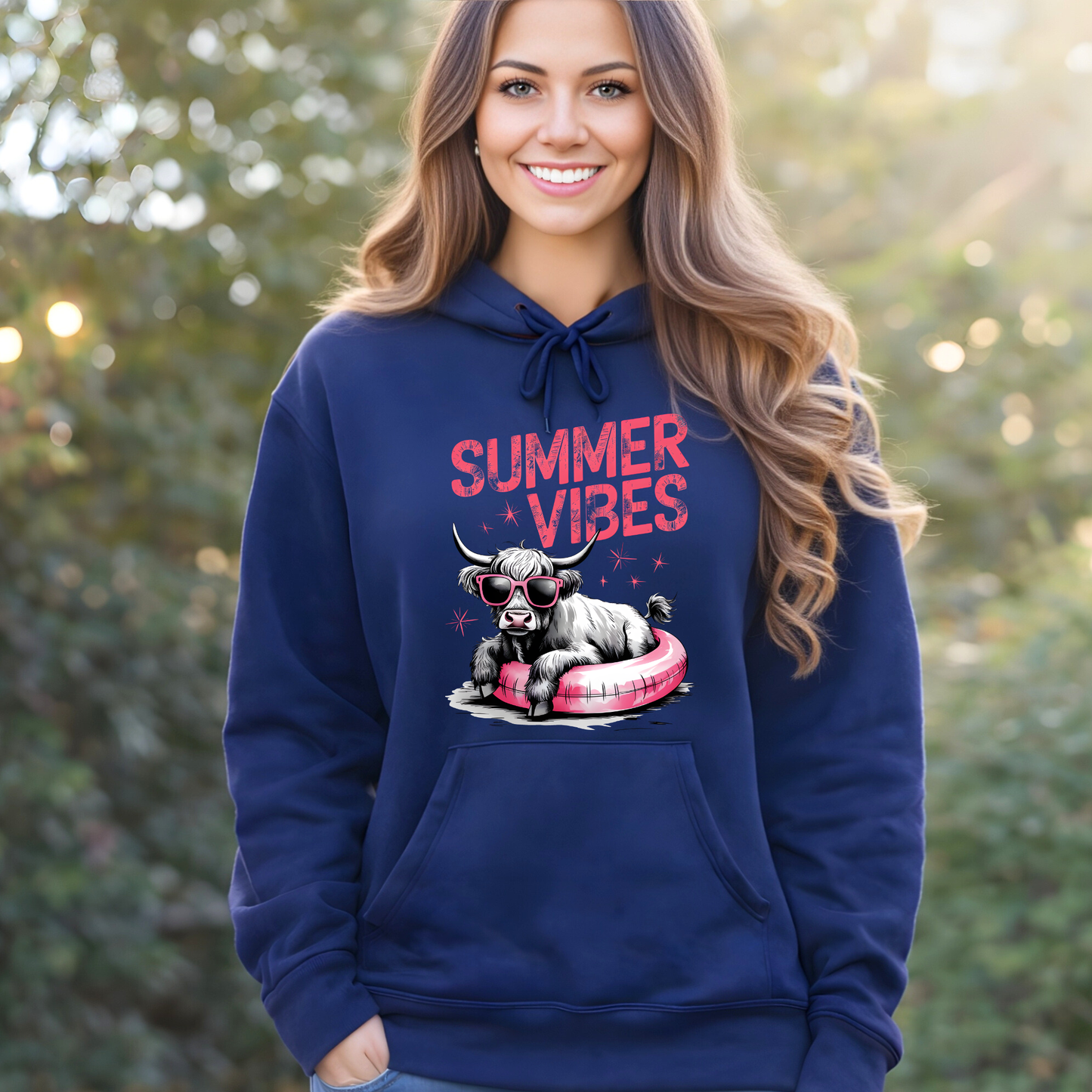 Woman wearing a navy blue hoodie with 'Summer Vibes' and a cow graphic, standing outdoors.
