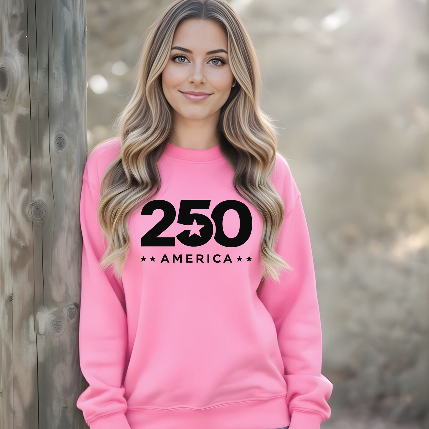 Woman wearing a pink sweatshirt with '250 America' text, standing against a wooden wall.