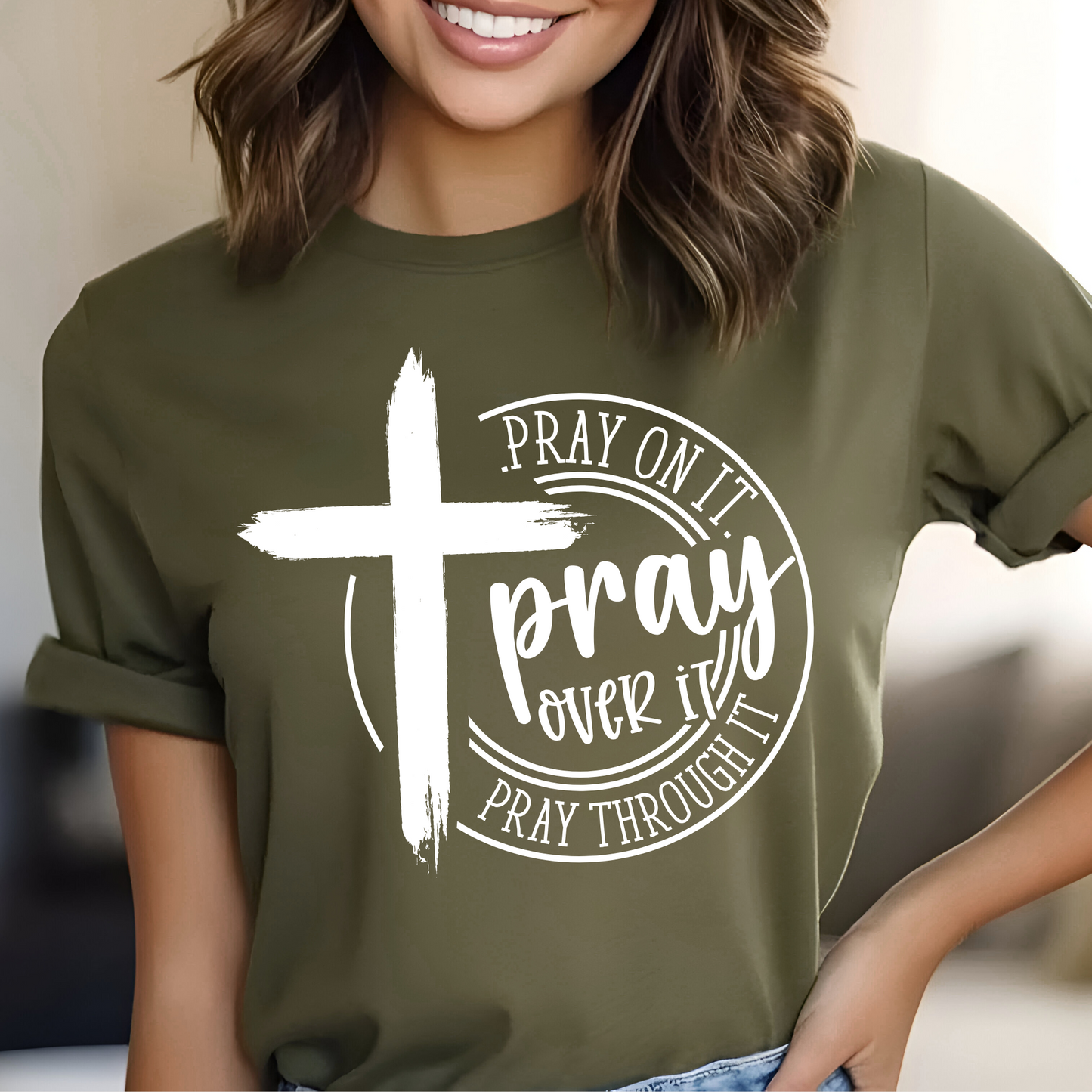 Person wearing a green t-shirt with a white cross and text design.