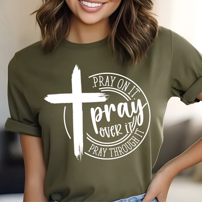 Person wearing a green t-shirt with a white cross and text design.