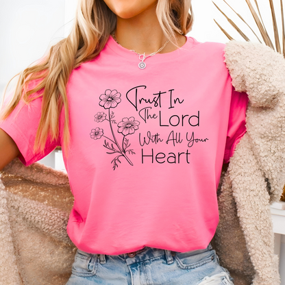 Woman wearing pink T-shirt with floral graphic and “Trust in the Lord With All Your Heart” text.