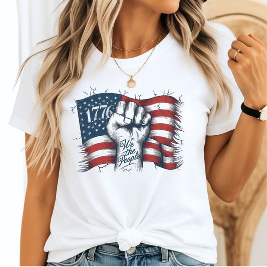 Woman wearing white 1776 We The People shirt with blue jeans, smiling – front view.

