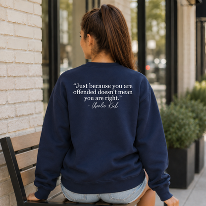 Back view of a woman seated outside in a navy crewneck sweatshirt with a white quote graphic.