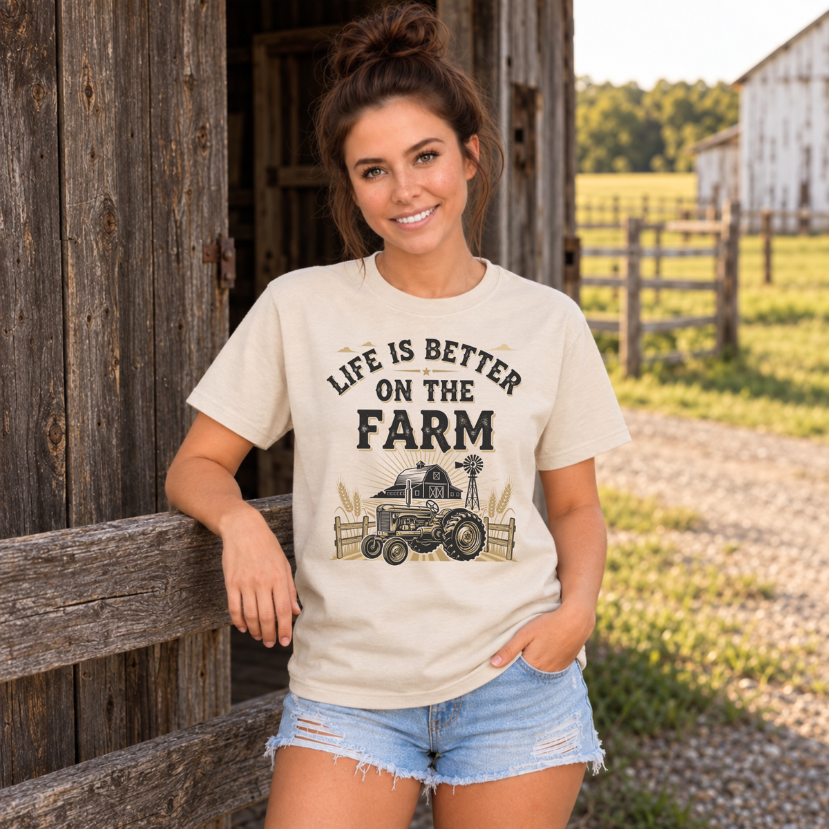 Woman in a sand Life Is Better on the Farm T-shirt leaning on a rustic barn railing.