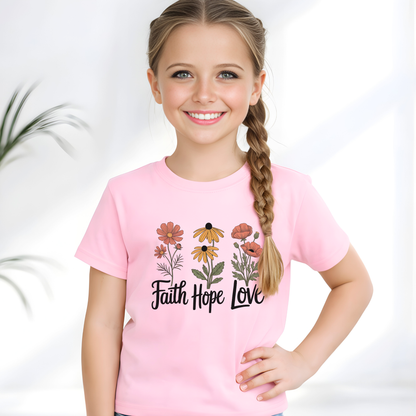 Young girl wearing a pink t-shirt with floral designs and 'Faith Hope Love' text on a white background