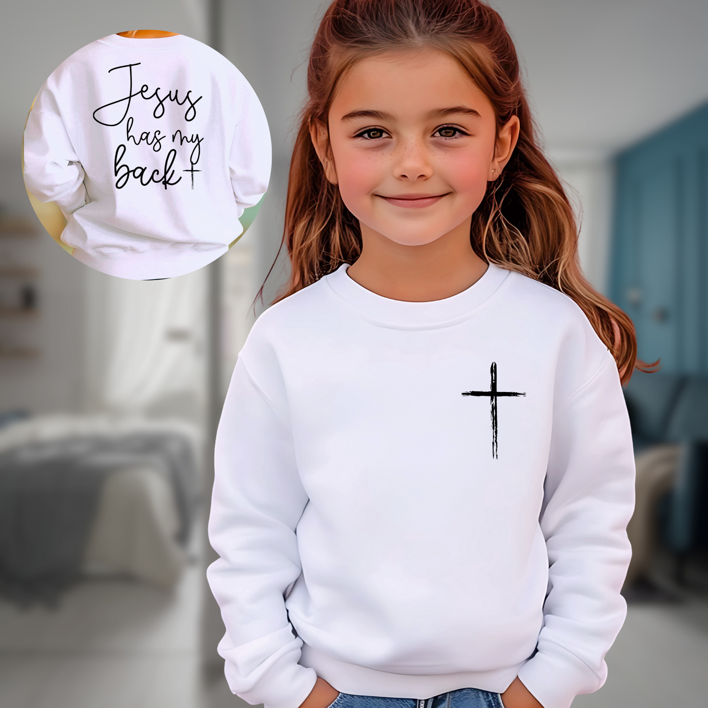 Young girl wearing a white 'Jesus Has My Back' youth sweatshirt with a cross design