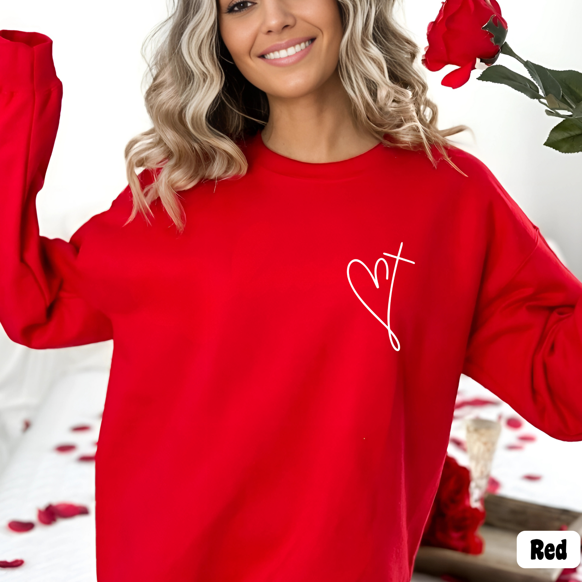 Woman wearing a red sweatshirt with minimalist heart and cross chest design, Valentine's Day outfit