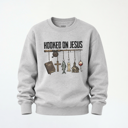 Sports gray youth crewneck sweatshirt flat lay with a Hooked On Jesus fishing rod graphic featuring a Bible, cross, fish, church, and bobber.