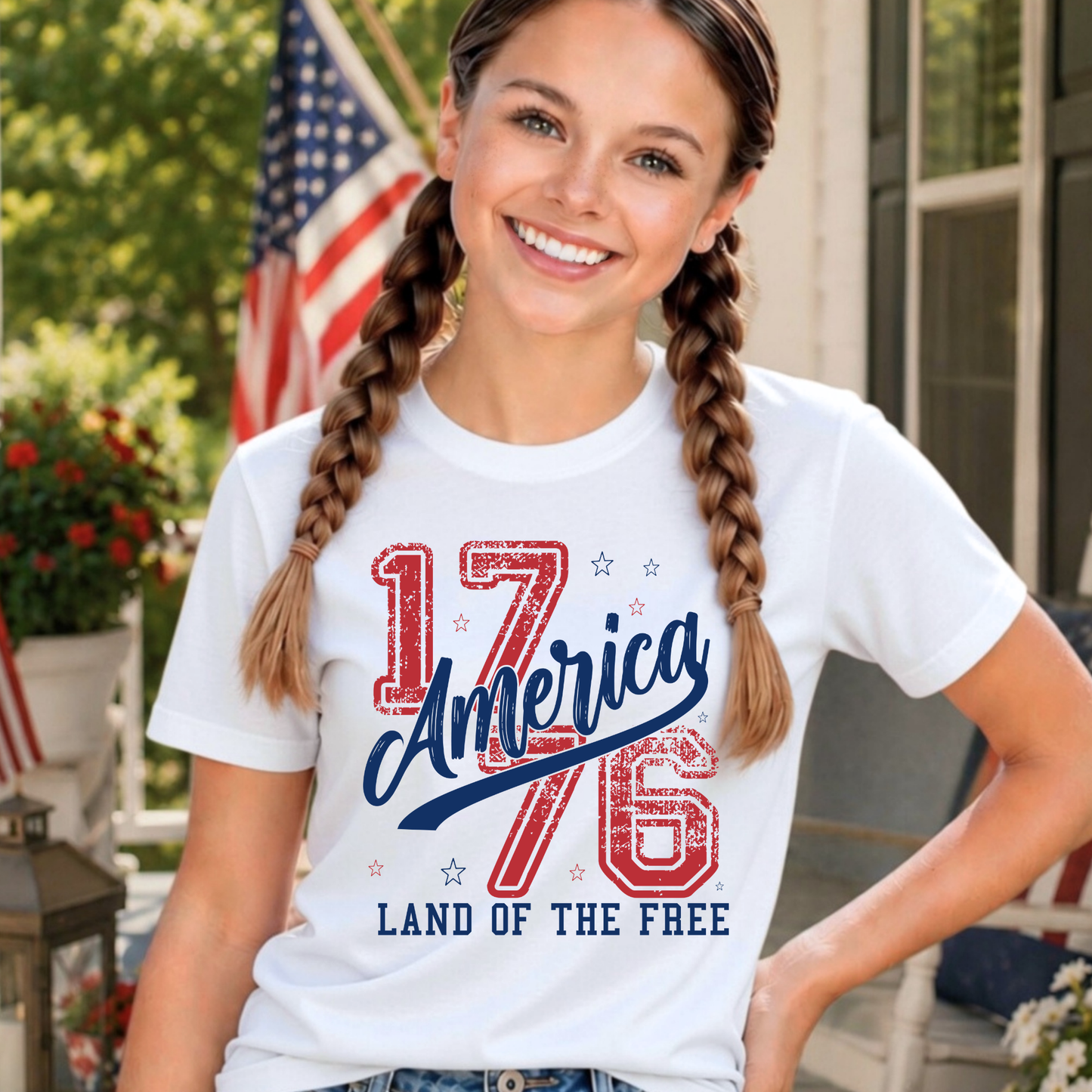 youth girl wearing a white t-shirt with '1776 America Land of the Free' design, standing outdoors.