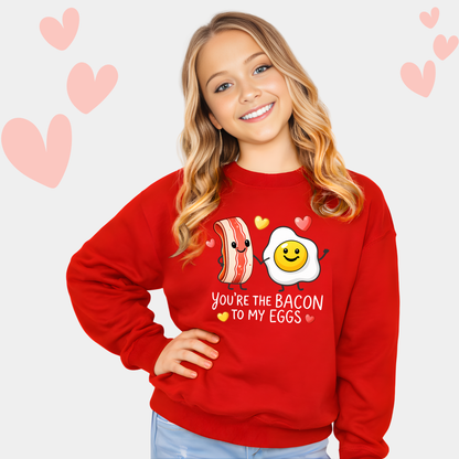youth girl wearing red valentine sweatshirt with you’re the bacon to my eggs graphic