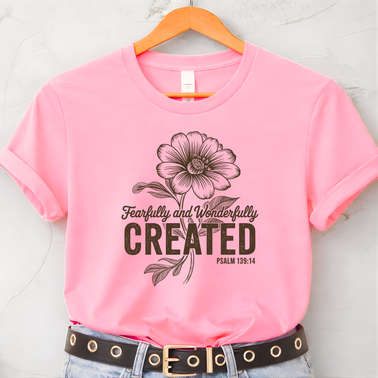 Light pink youth t-shirt with Fearfully and Wonderfully Created floral design on hanger