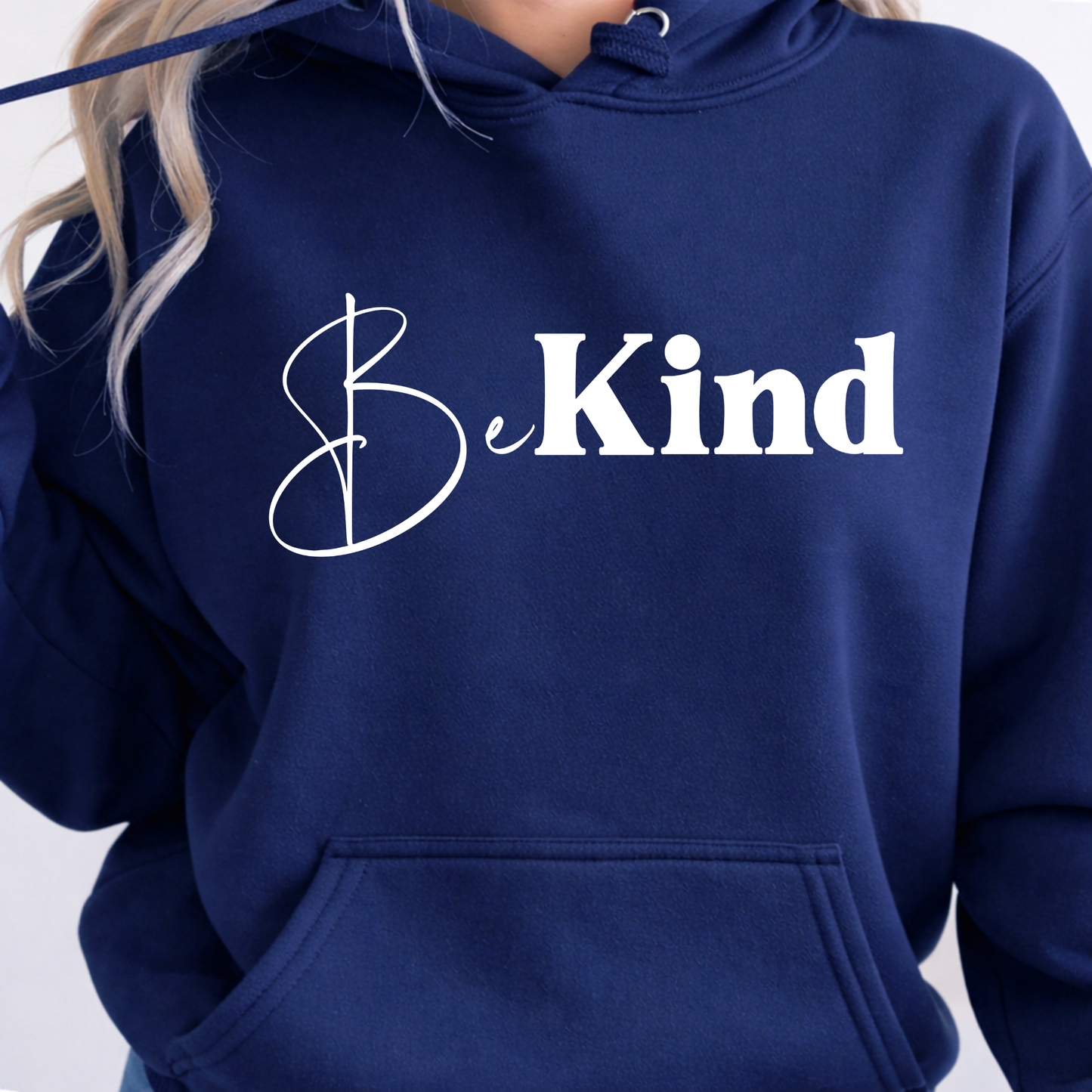 Navy blue hoodie with 'Be Kind' text on a plain background