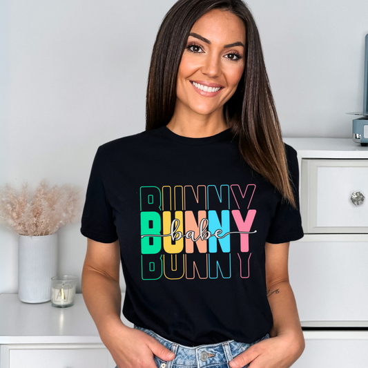 Trendy Bunny Babe graphic t-shirt with colorful pastel typography, perfect for Easter outfits, spring fashion, and casual wear. Soft cotton tee for women.