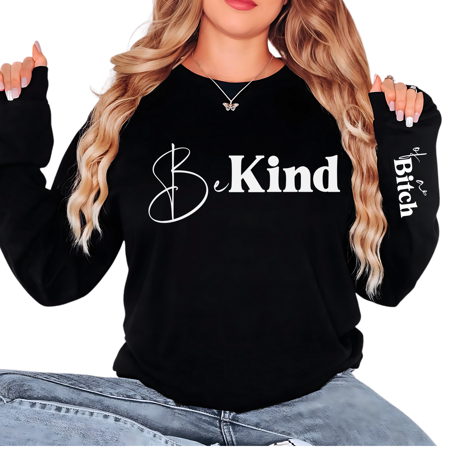 Black sweatshirt with 'Be Kind' text, worn by a person.