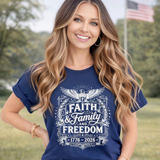 Woman wearing a blue t-shirt with 'Faith & Family and Freedom' text, standing outdoors with trees and an American flag in the background.