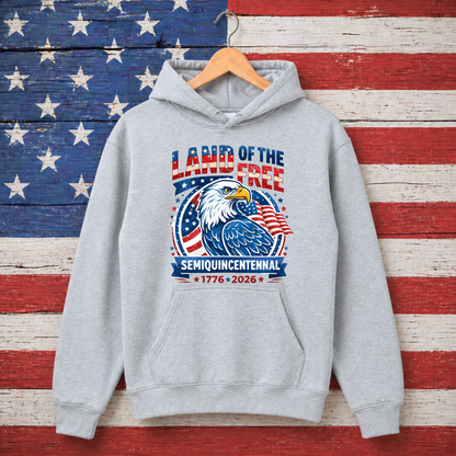 Gray hoodie with 'Land of the Free' design on a wooden background resembling the American flag.