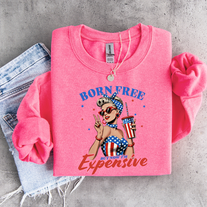 Pink sweatshirt with graphic American Woman  design and text on a concrete surface