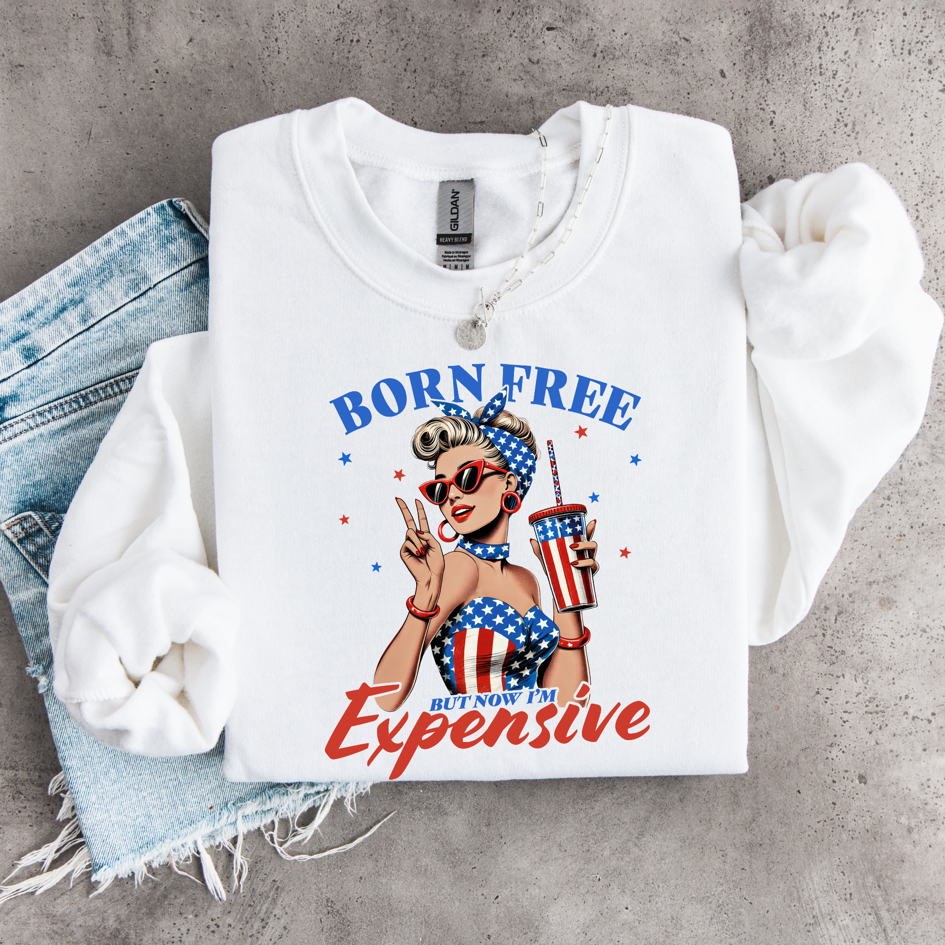 White sweatshirt with graphic  retro American Woman design and text on a concrete surface