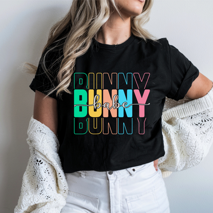 Trendy Bunny Babe graphic t-shirt with colorful pastel typography, perfect for Easter outfits, spring fashion, and casual wear. Soft cotton tee for women.