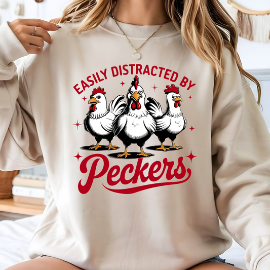 Beige sweatshirt with cartoon chickens and text 'Easily Distracted by Peckers' worn by a woman.