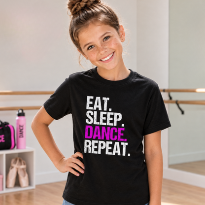 Girl wearing a black youth Eat Sleep Dance Repeat T-shirt with pink DANCE lettering in a dance studio.