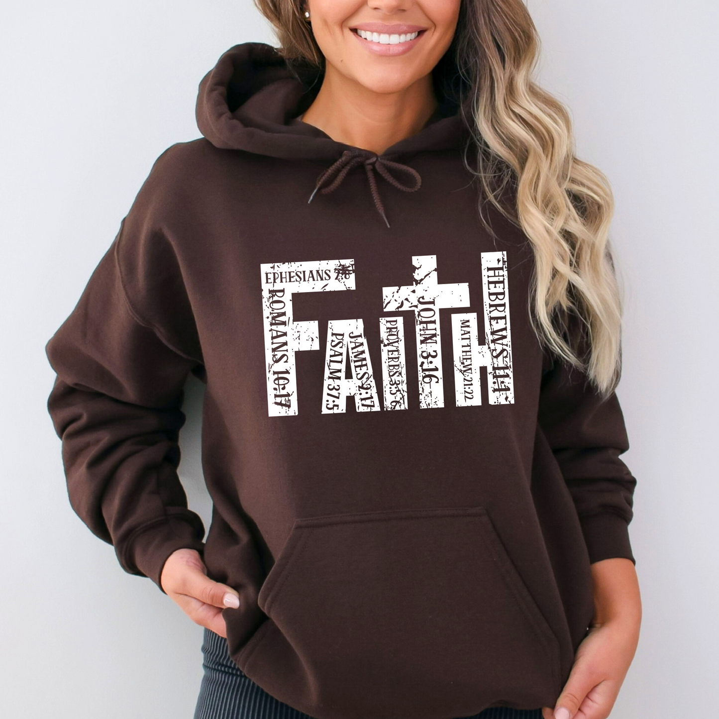 Brown Christian hoodie featuring 'FAITH' in bold distressed white letters, designed with Bible verse references including John 3:16, Romans 10:17, Hebrews 11:1, and more. Inspirational religious sweatshirt for faith-based fashion.