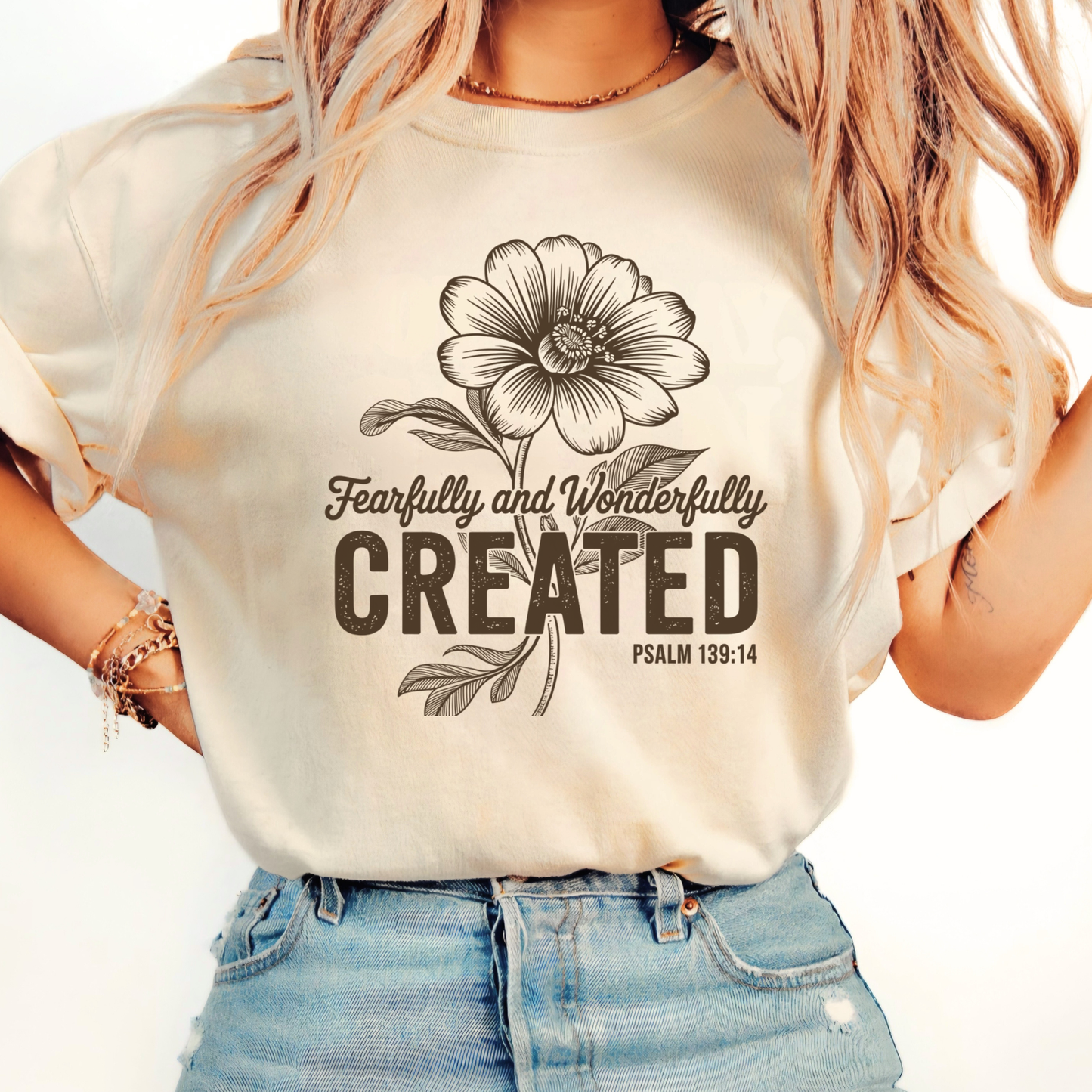 Woman wearing a neutral beige floral Faith t-shirt with motivational message